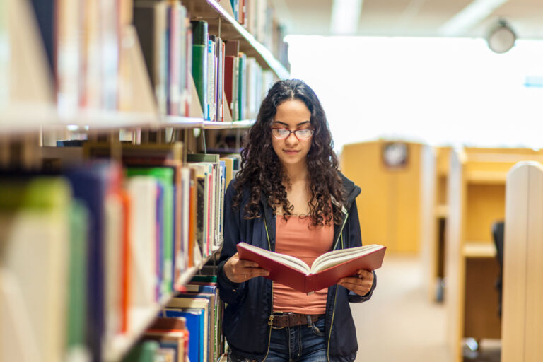 A young woman reads a book in the library