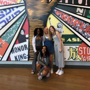 Smiling group of students in front of a civil rights mural