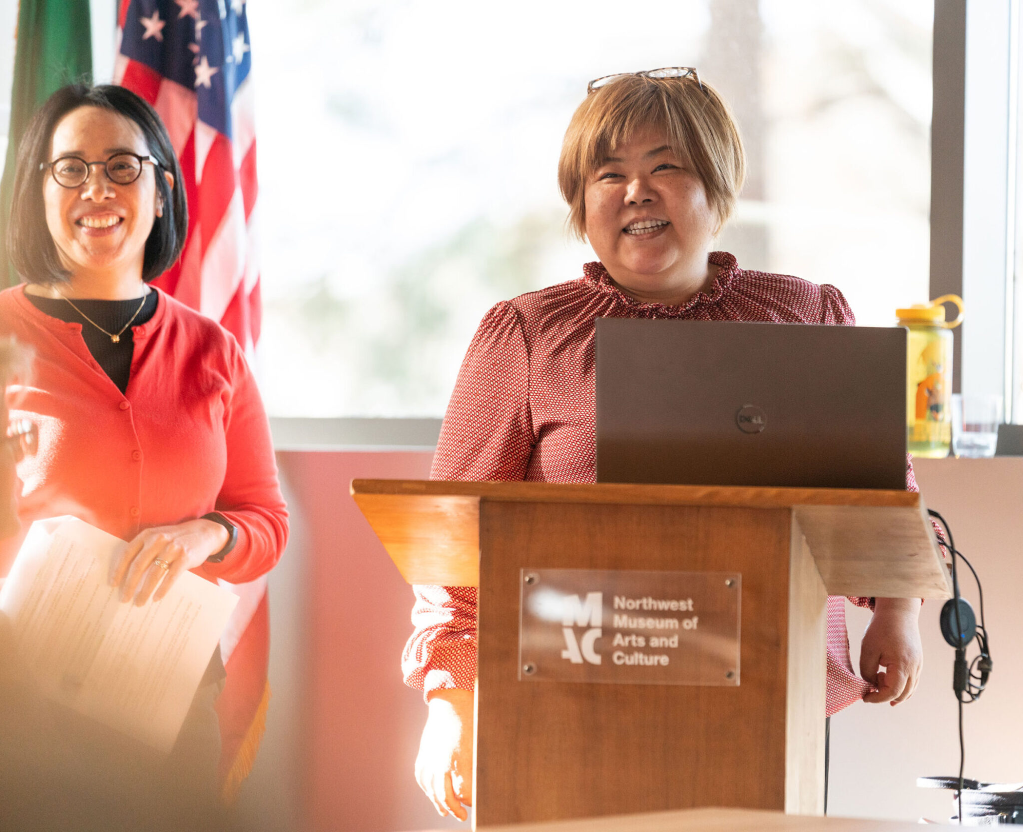 Two professors at a podium smiling