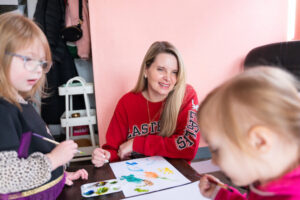 An EWU alumna works on an art project with children at a local school