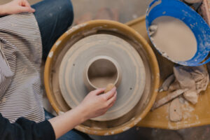 An EWU art student uses a pottery wheel to create a small bowl