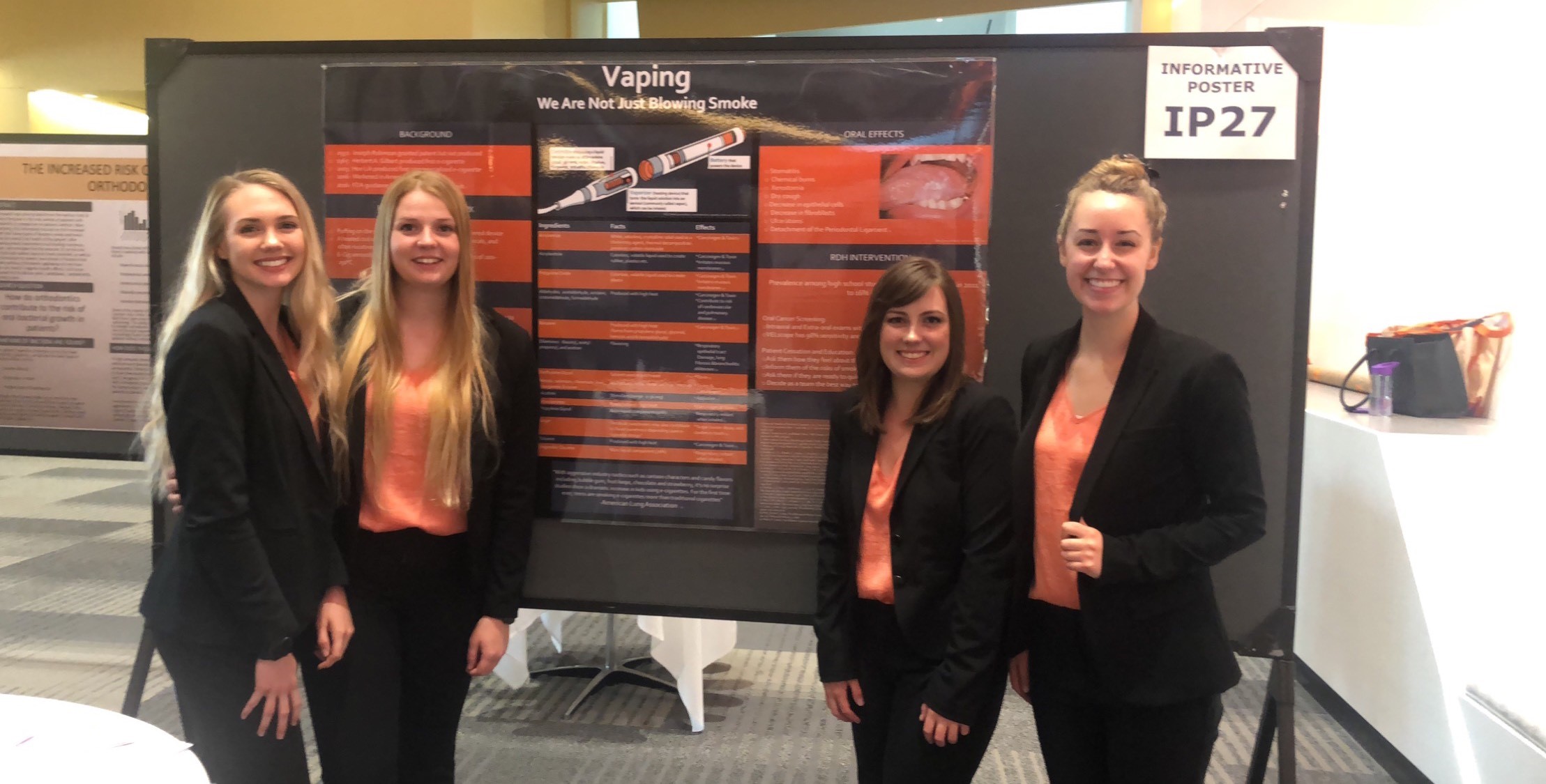 Students pose with a research poster about vaping