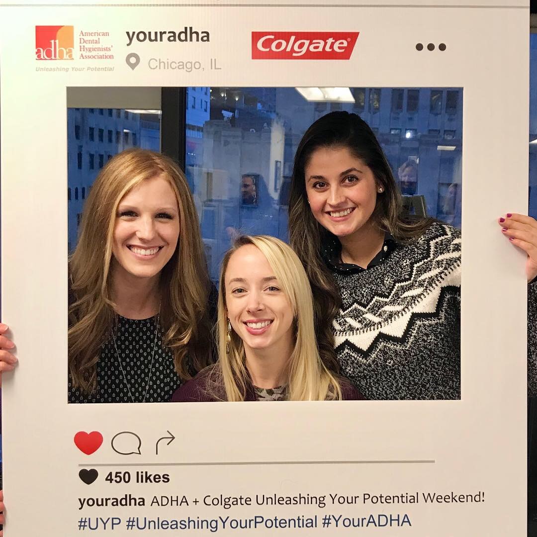Dental hygiene faculty pose with Instagram prop