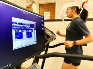 female running on a treadmill while hooked up to a monitor