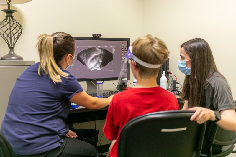 Two students working with a youth on speech.