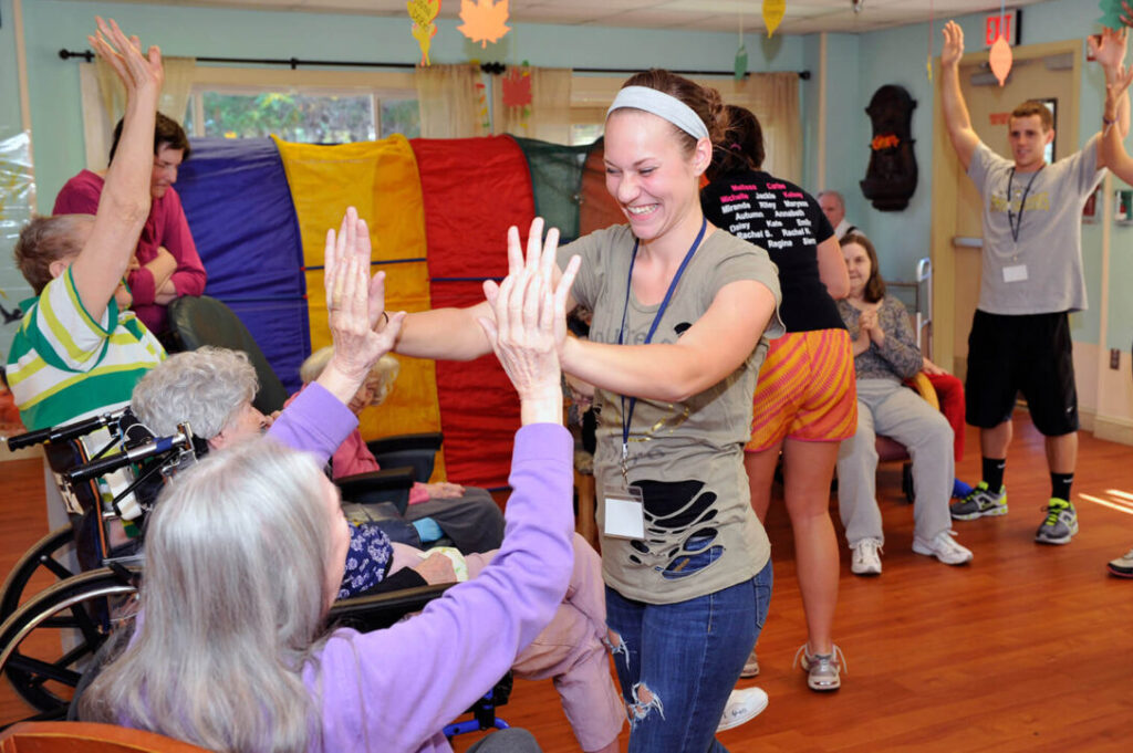 A Therapeutic Recreation Specialist gives a patient a high-five.