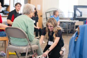An EWU exercise students helps an elderly lady with a movement activity