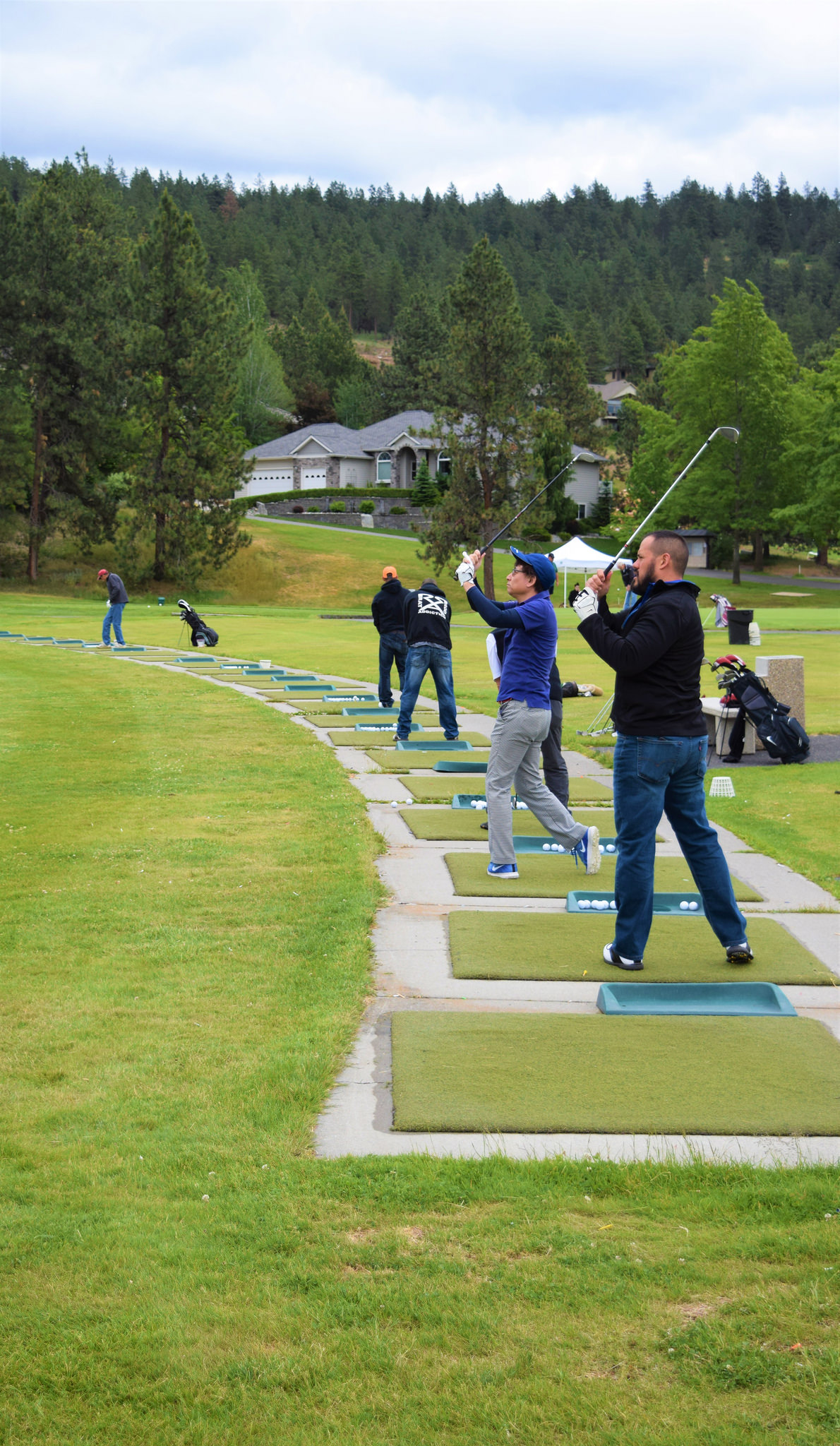 Golf players line up to practice swinging