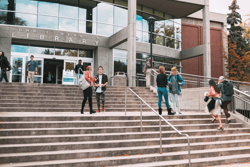 Students walk up the steps to the library