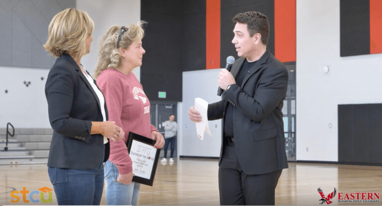 two people presenting an award to the new teacher of the month.