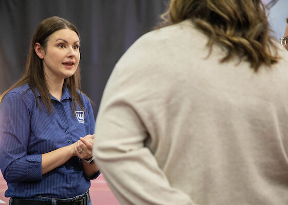 A woman talks to students at the Career Fair