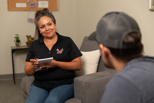 A counselor talks with a patient in a room