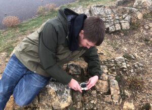 student studying rock formation with tools