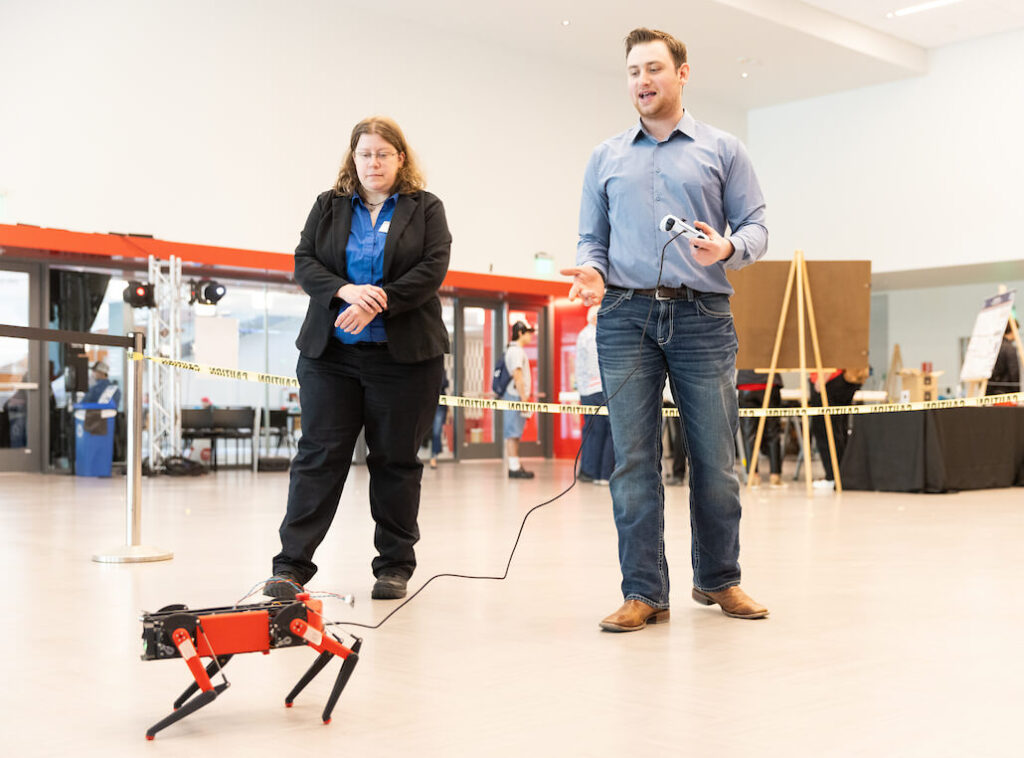Student demonstrates a robotic dog project to their professor