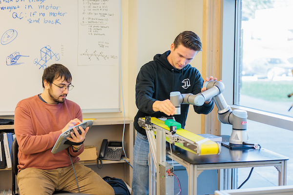 Two students collaborate on a physics project in class