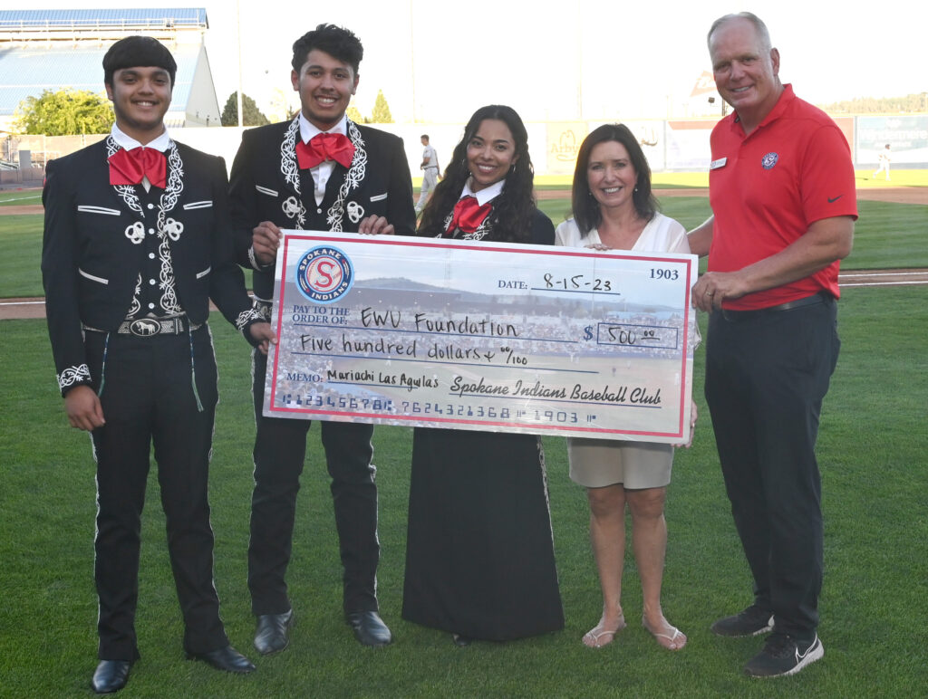 Mariachi club holding a large check