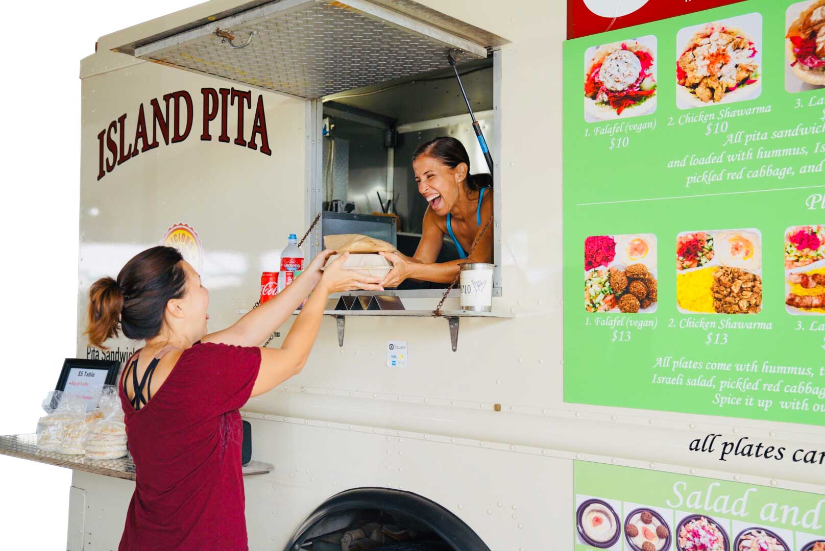 A customer picks up an order of food from the Island Pita food truck
