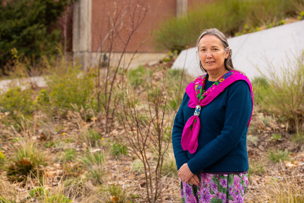 Melodie Wynne stands in front of indigenous plants at EWU.