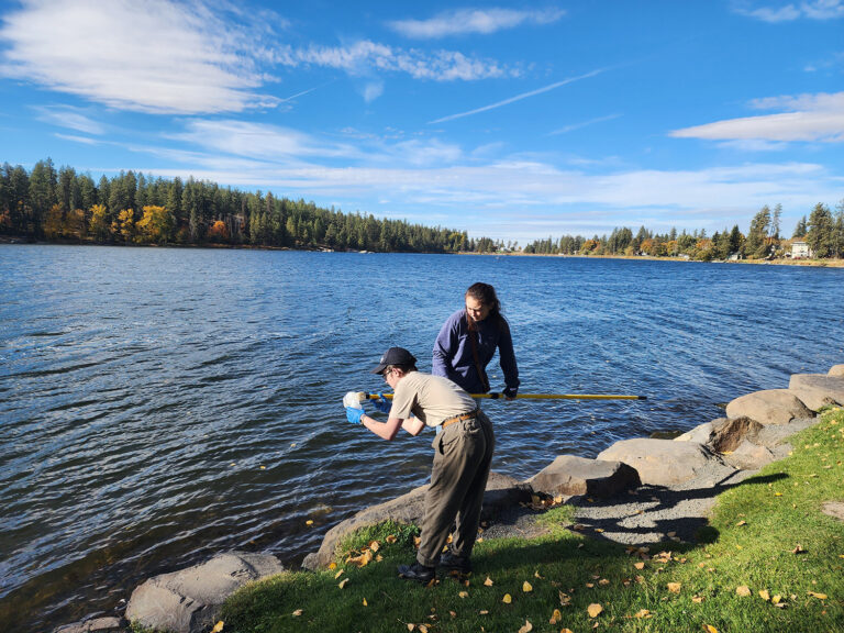 EWU geosciences students Basil Lund [left] and Cadence Meier-Grolman collect lake water samples near Spokane County’s West Plains. Photo by Chad Pritchard.
