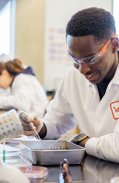 biology student in lab gear performs testing