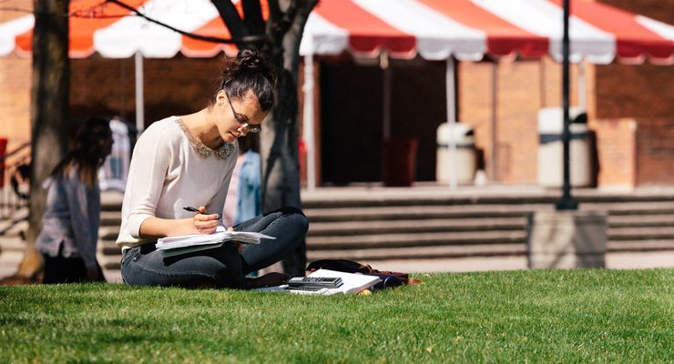 Woman studying on the grass outside