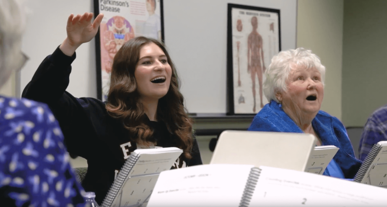 Student singing with older women.