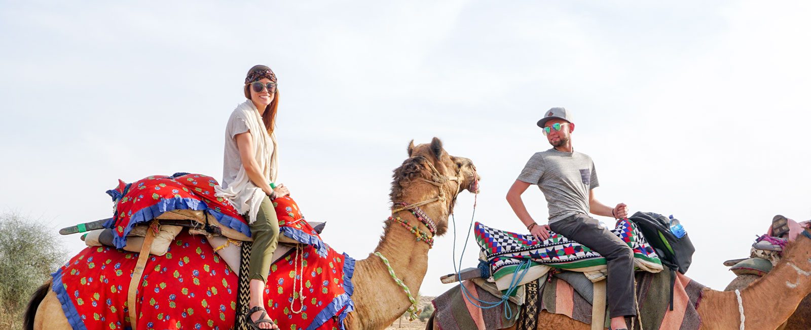 EWU alumni couple riding camels in the desert of India