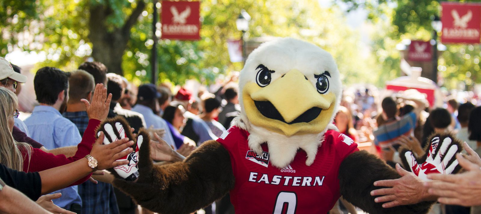 Photo: Swoop Eagle mascot with students at Pass Through the Pillars event