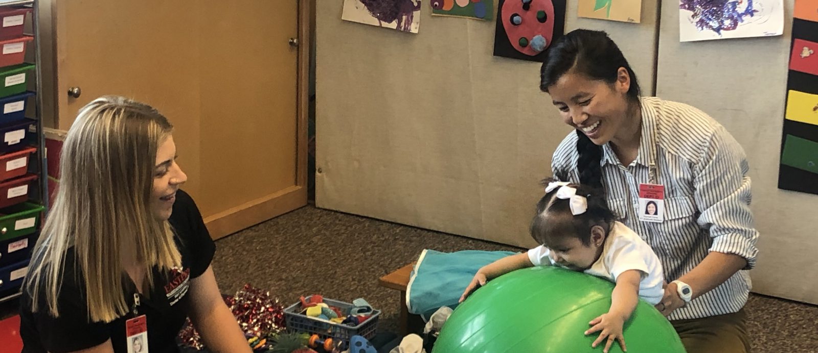 Student physical therapists work with a small child