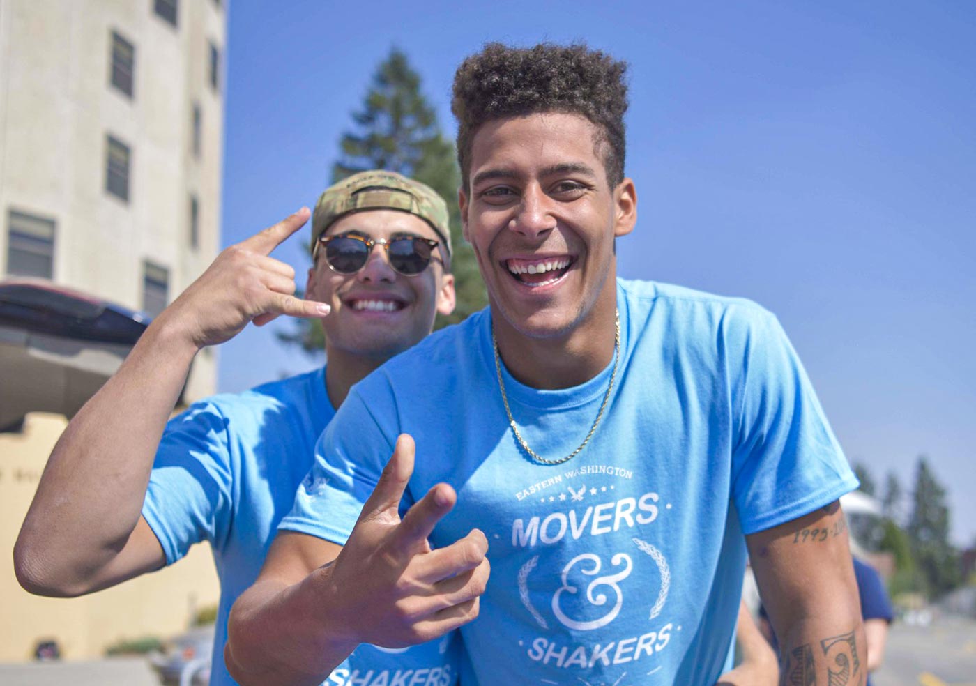Photo: two male students in "Movers & Shakers" T-shirts pose during Move-In Day