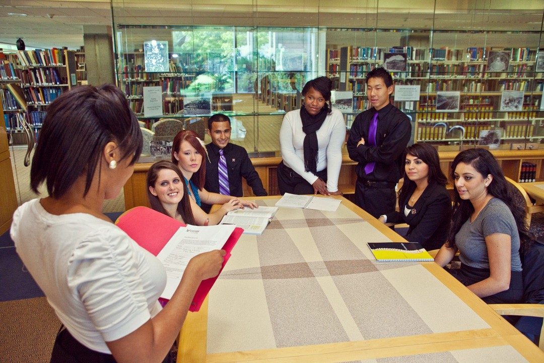 Group of students in the library sitting around a table.