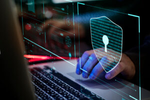 Photo of hand on a keyboard with a cyber background.