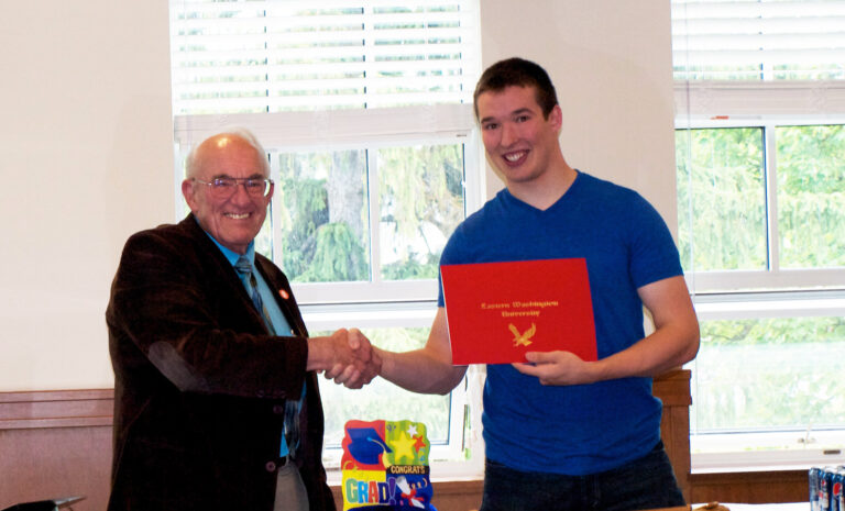 Professor Trulove is pictured congratulating a student, who is holding his diploma.