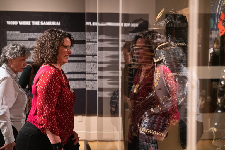 Woman looking at Japanese armor display at the MAC.