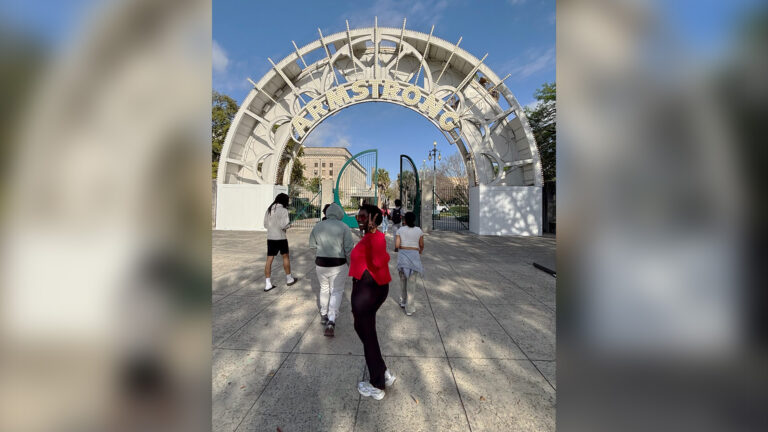 Abak Anei flashes the peace sign while entering Louis Armstrong Park in New Orleans.