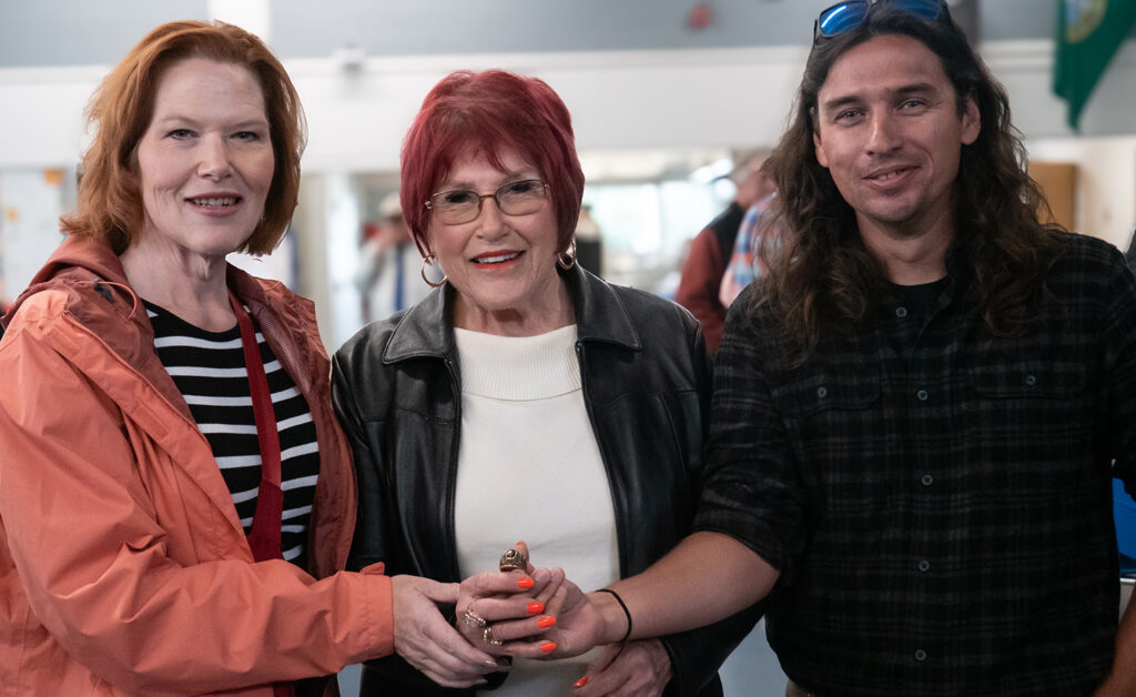 Linda Wall-Sullivan Center, her daughter, Laura, and ring finder James Murphy hold on to the ring together.