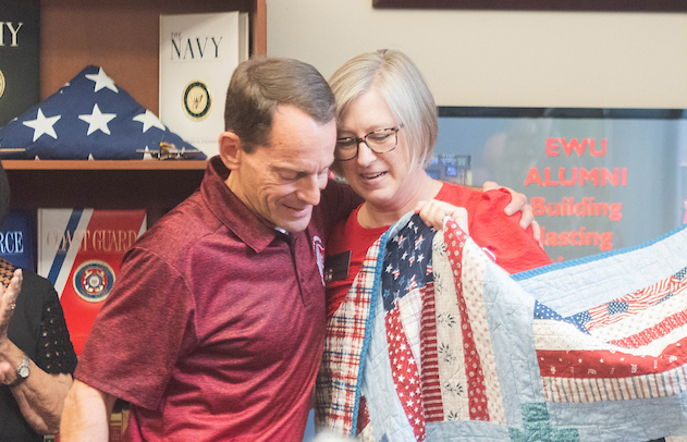 Dave Millet and Lena Tanguay hugging after she presents him with a handmade quilt.