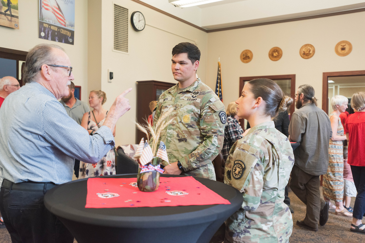 Two ROTC students talking to Alan Basham.
