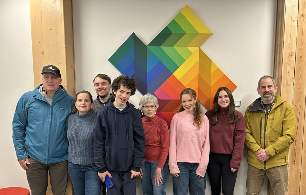 Picture of the late faculty member's family under the painting. There are 8 family members including his wife who donated the art.