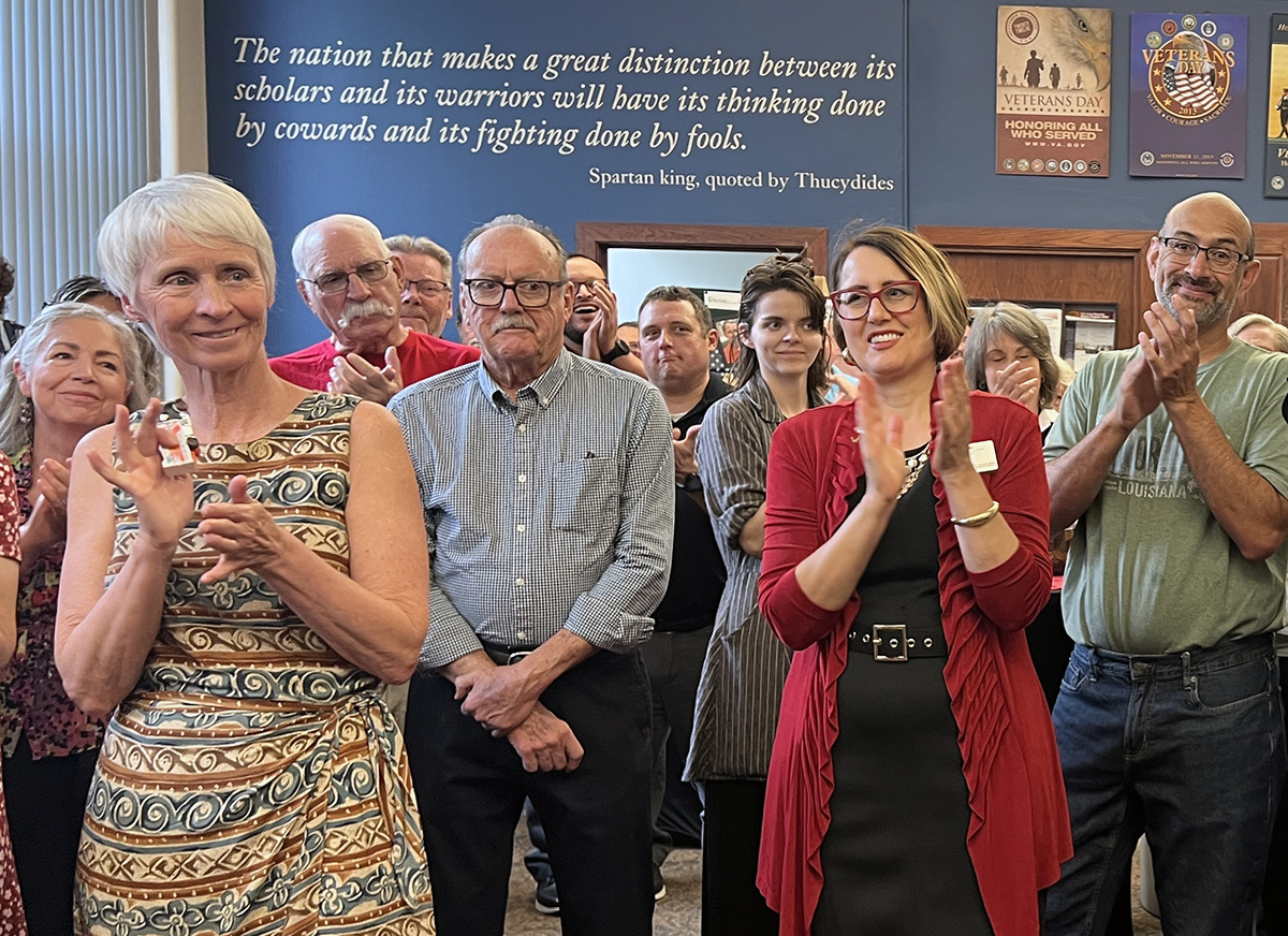 Attendees, including Dave Millet's wife, clapping after the announcement was made.