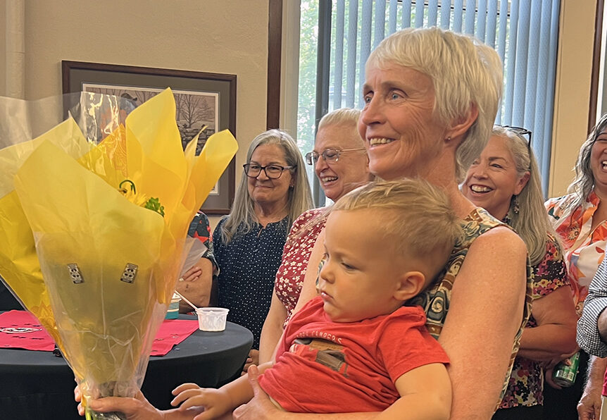 Dave Millet's wife, Trudy, holding flowers and their grandson.