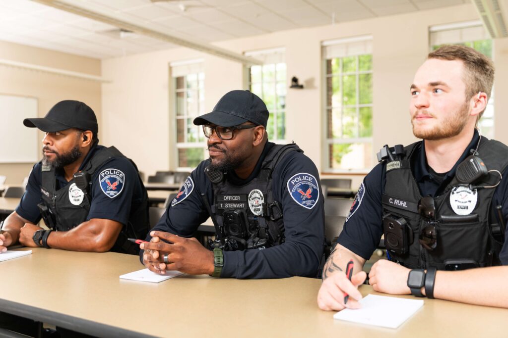 Three police officer in an Eastern Washington University classroom.