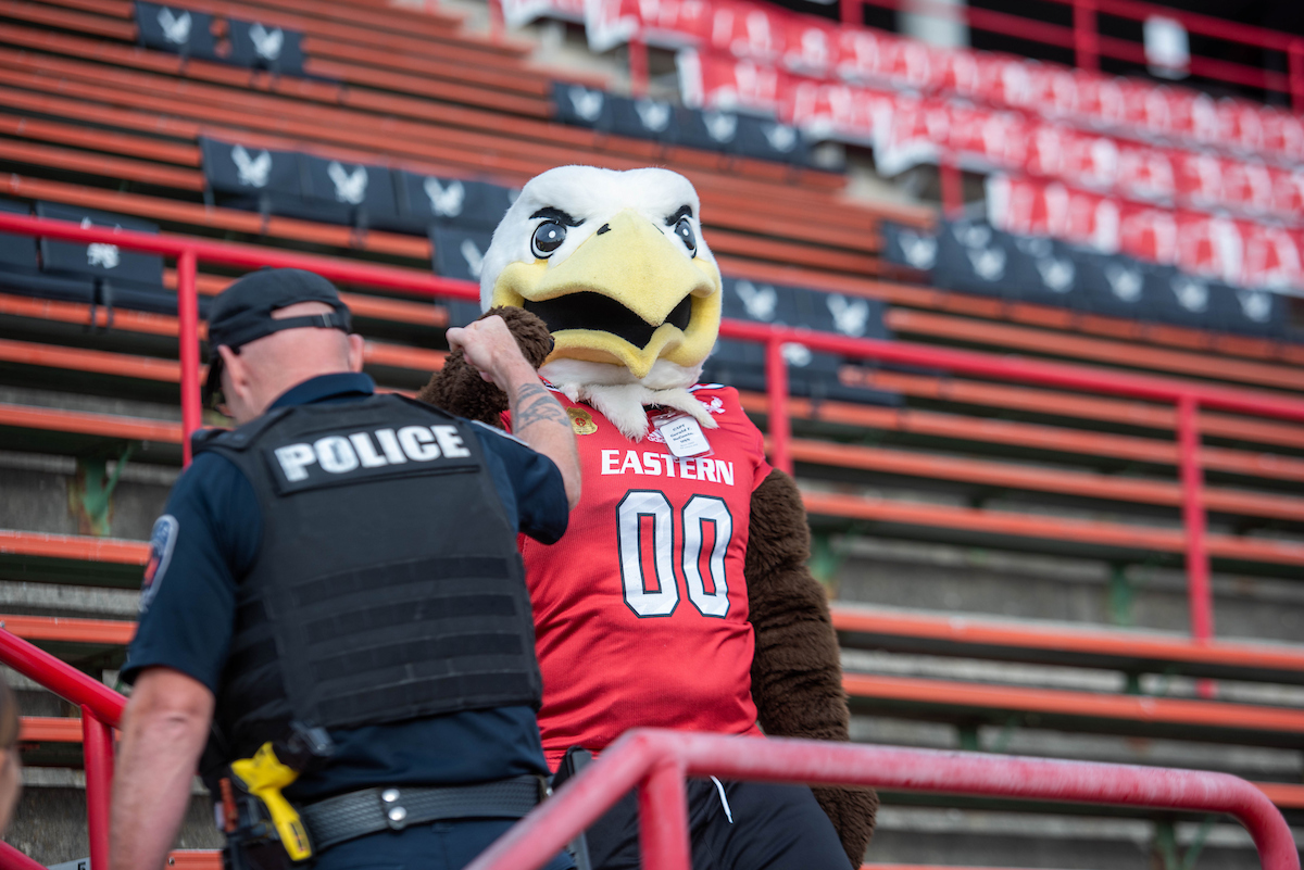 Swoop gives a hi-five to a police officer climbing the steps.