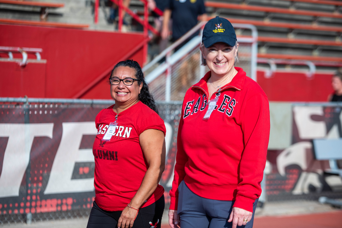 Two EWU staffers wearing red walk the track.