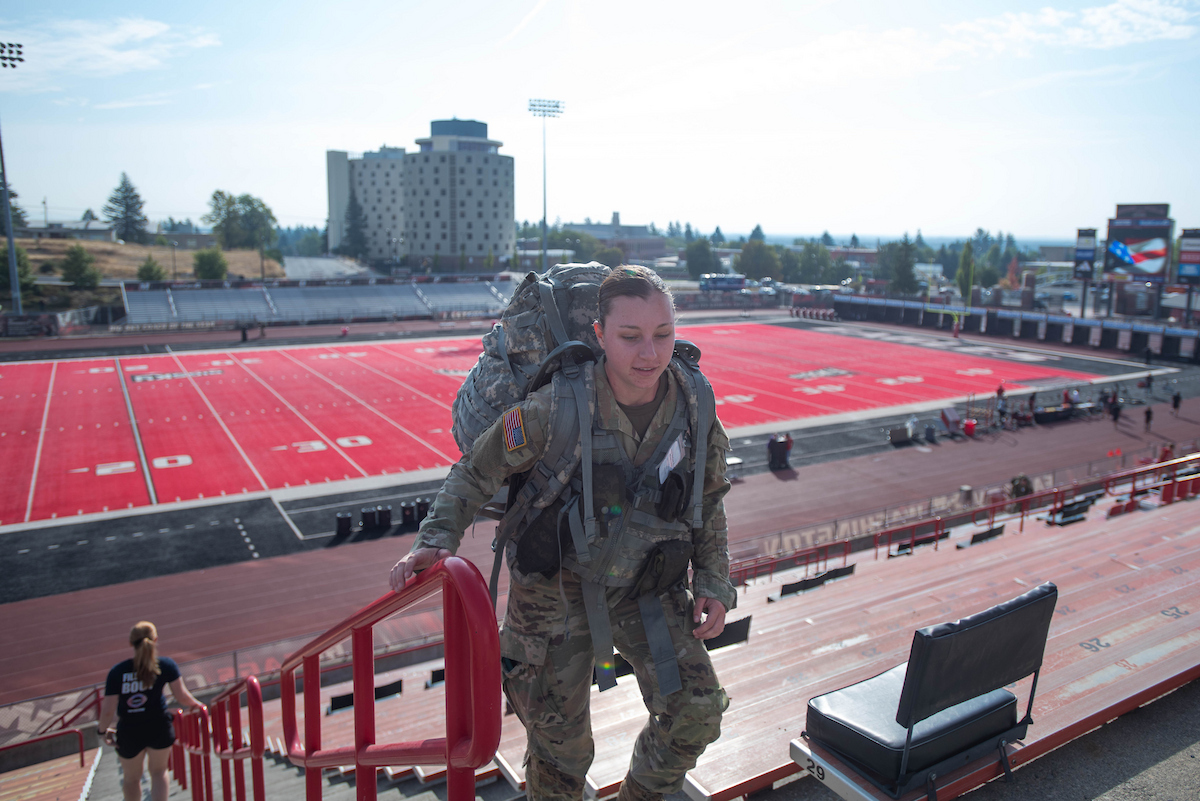 ROTC student climbing the steps with a backpack.