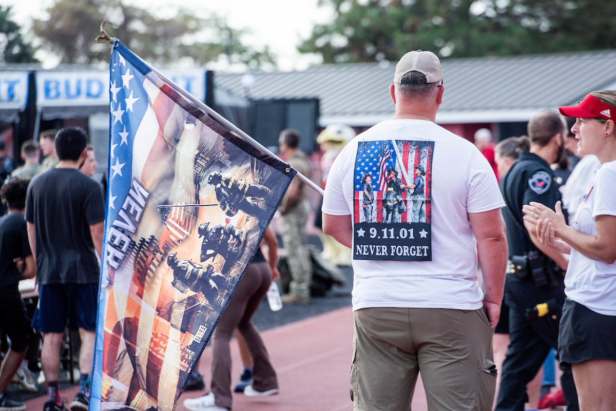 Man wearing a 9-11 "Never Forget" T-shirt and carrying a special flag.