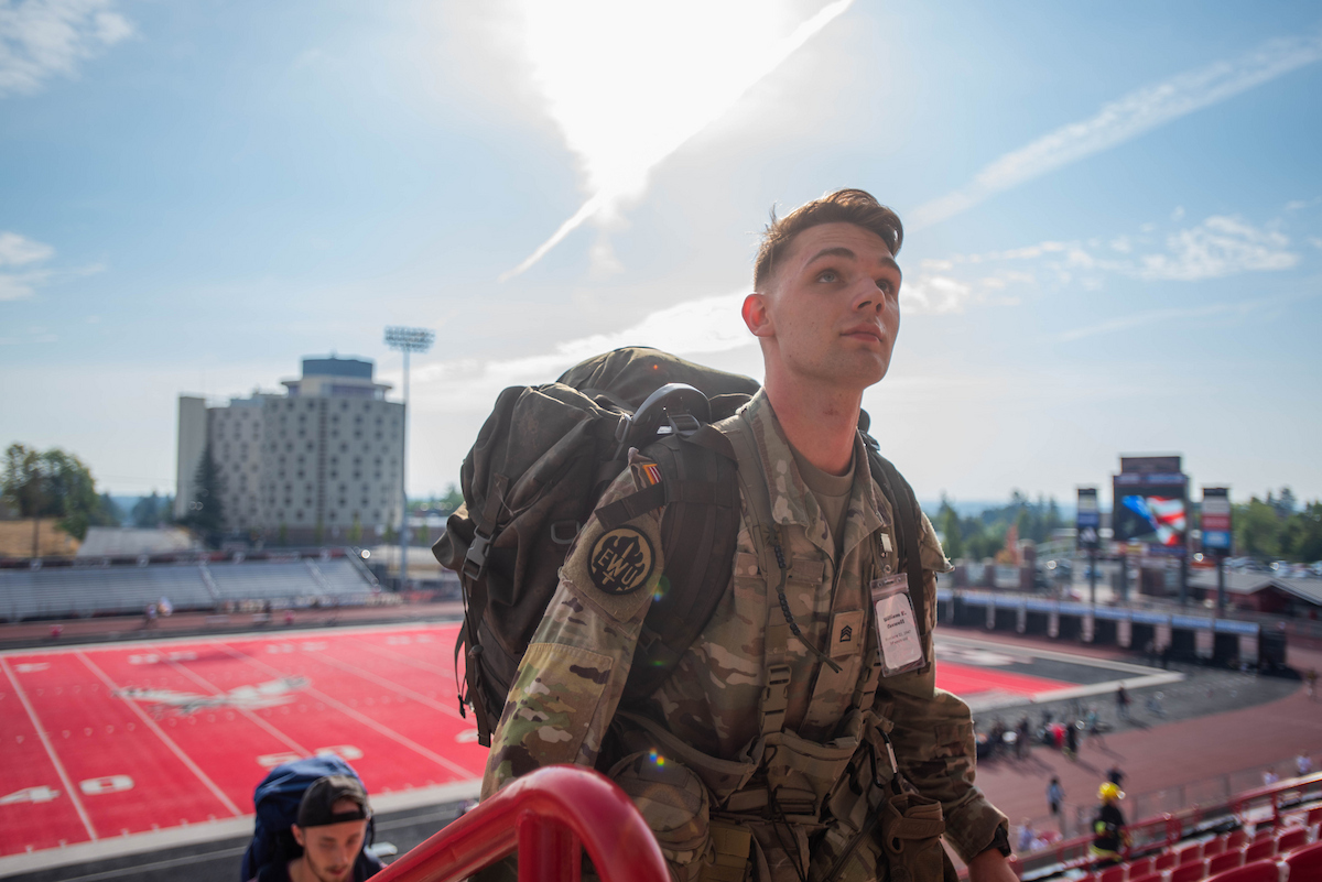 ROTC student reaches the top of the steps while carrying a full backpack.