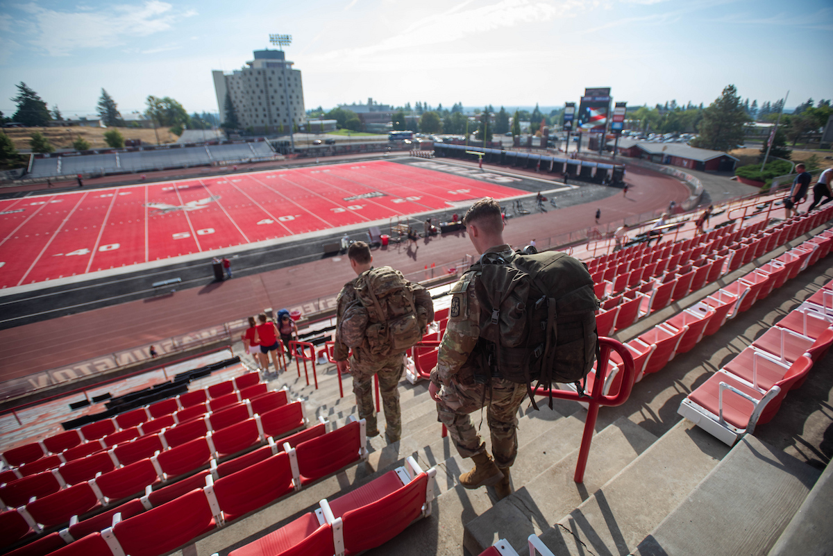 Two ROTC students with packs go down the steps.