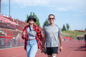 An EWU staff member and retiree walk the track.