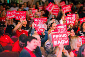Attendees hold up Eagle Pride signs